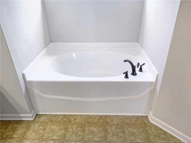 bathroom featuring tile patterned floors, baseboards, and a bath