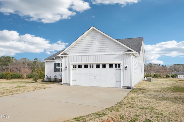 exterior space featuring driveway, a garage, board and batten siding, roof with shingles, and central AC