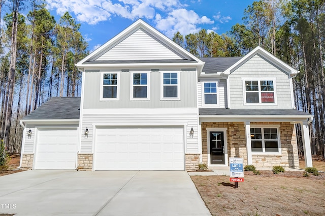 view of front of property featuring stone siding, concrete driveway, and a garage