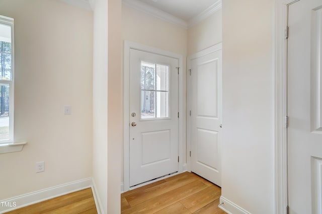 doorway featuring ornamental molding, light wood-type flooring, a wealth of natural light, and baseboards