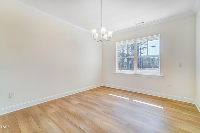 empty room featuring ornamental molding, baseboards, visible vents, and light wood finished floors