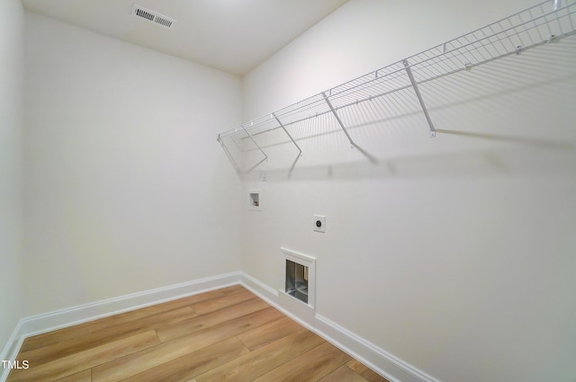 washroom with hookup for a washing machine, visible vents, light wood-style floors, laundry area, and baseboards