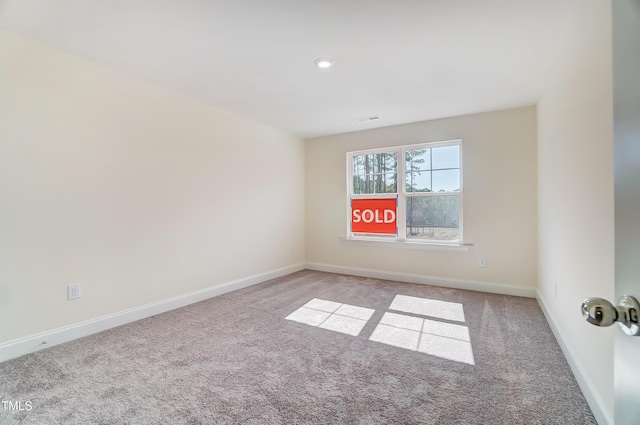 empty room featuring carpet, baseboards, and recessed lighting