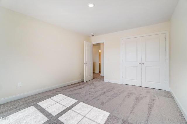 unfurnished bedroom featuring a closet, baseboards, and carpet flooring