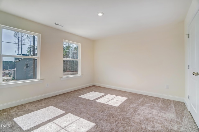 spare room featuring baseboards, visible vents, and carpet flooring