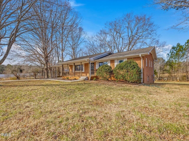 ranch-style home with covered porch, a front yard, and brick siding