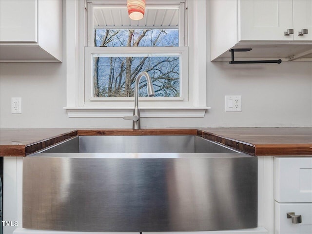 interior space with a sink and white cabinets