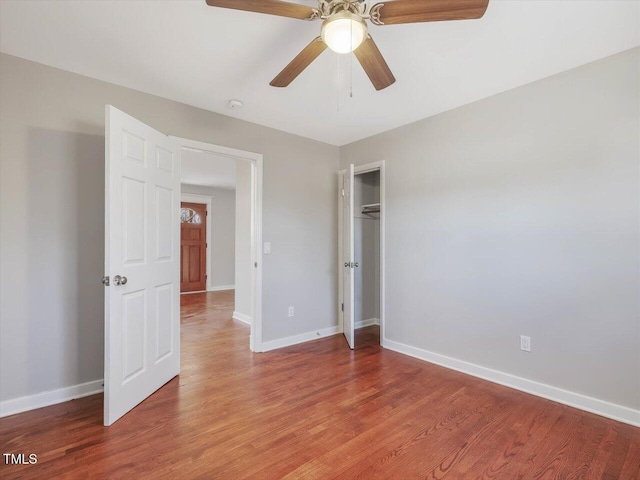 empty room featuring a ceiling fan, baseboards, and light wood finished floors