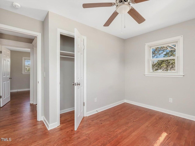 unfurnished bedroom featuring a closet, baseboards, and wood finished floors