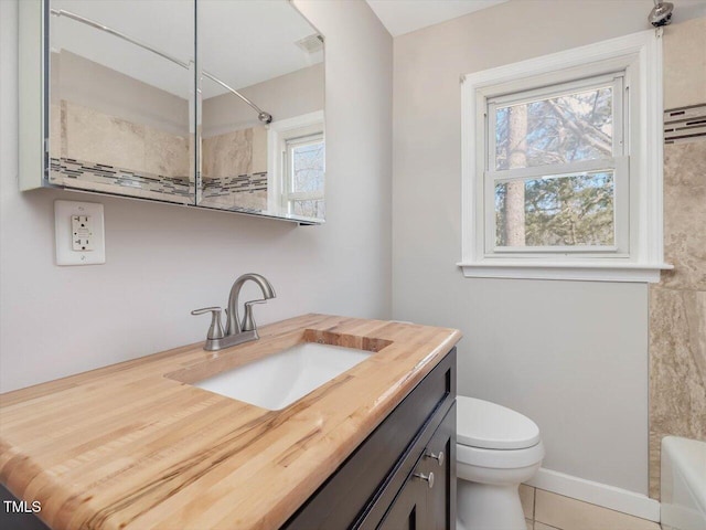 bathroom with toilet, plenty of natural light, visible vents, and vanity