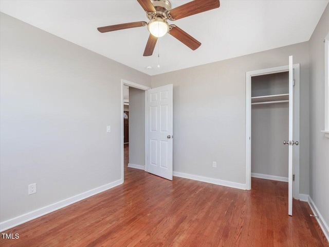 unfurnished bedroom with a closet, baseboards, and wood finished floors