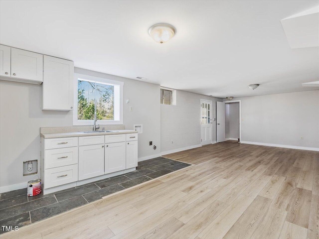 kitchen with baseboards, white cabinets, wood finished floors, and open floor plan