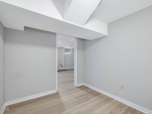 below grade area featuring light wood-style flooring and baseboards