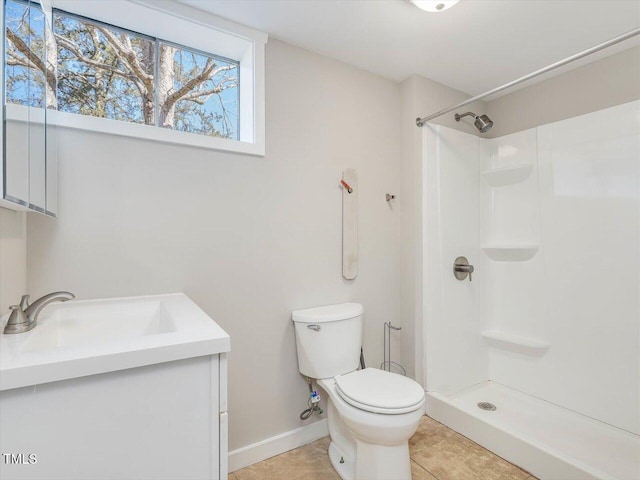 full bathroom featuring baseboards, toilet, tile patterned floors, walk in shower, and vanity