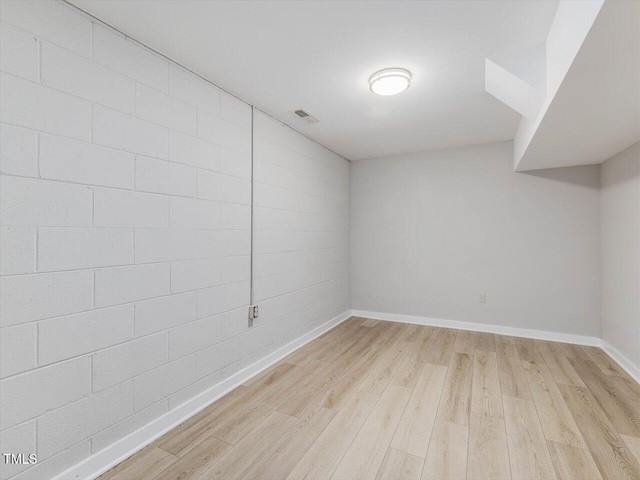 unfurnished room with visible vents, light wood-style flooring, and baseboards