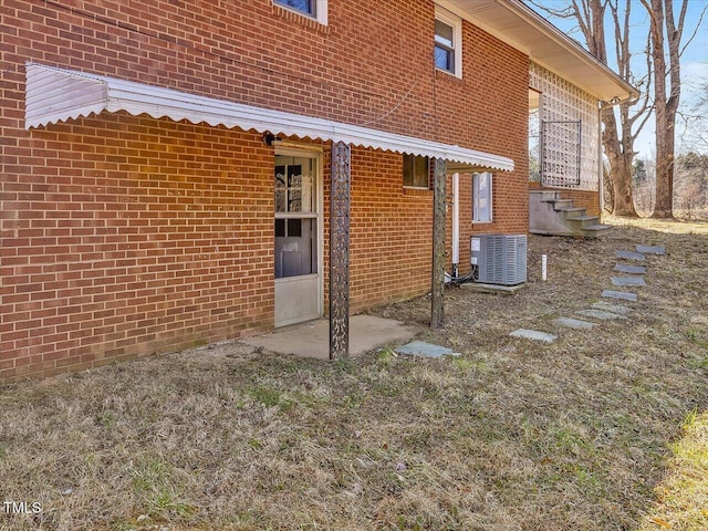 view of property exterior featuring central AC and brick siding