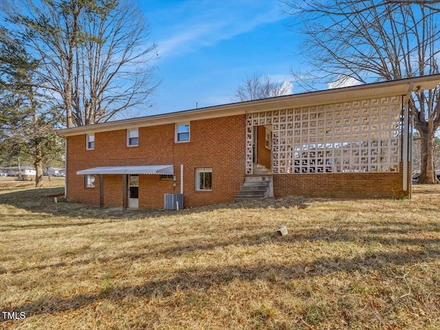 rear view of property featuring brick siding and a yard