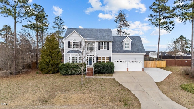 view of front facade featuring driveway, roof with shingles, a front yard, and fence