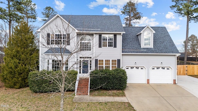 view of front of home with driveway, fence, and roof with shingles