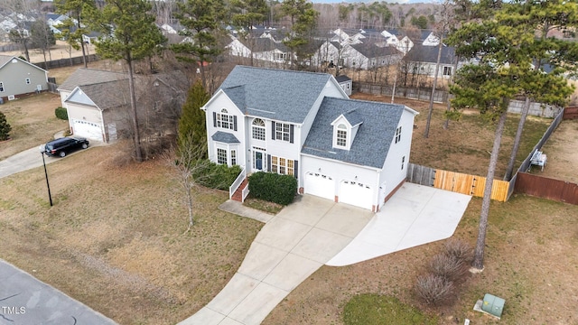 view of front of house featuring a garage, a shingled roof, fence, driveway, and a residential view