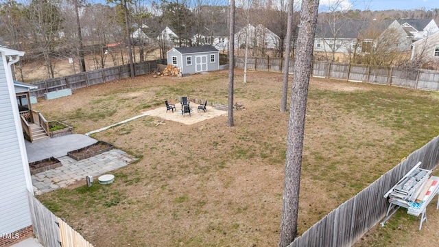 view of yard with a fenced backyard, a storage unit, an outdoor structure, and a patio