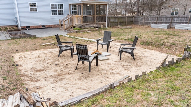 view of yard featuring a sunroom, a patio area, fence, and a fire pit