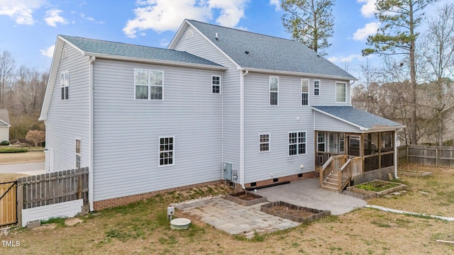 back of house featuring a shingled roof, a patio, a sunroom, a fenced backyard, and crawl space