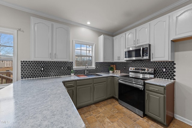 kitchen featuring stainless steel appliances, tasteful backsplash, a sink, and white cabinets