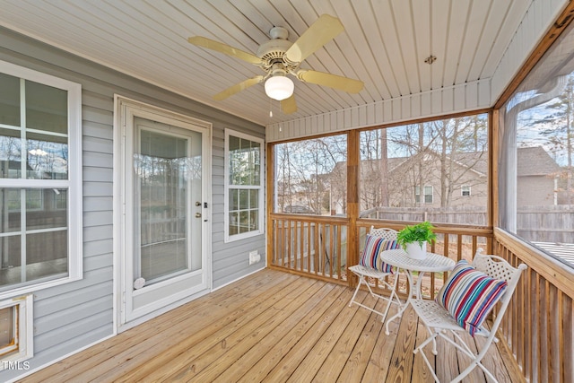 sunroom / solarium with wood ceiling, a healthy amount of sunlight, and ceiling fan