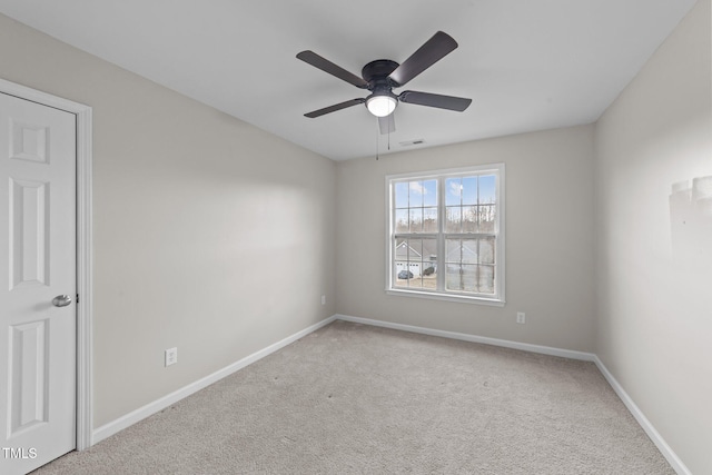 carpeted spare room with visible vents, ceiling fan, and baseboards