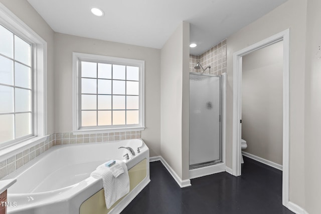 bathroom featuring toilet, a stall shower, a wealth of natural light, and a bath