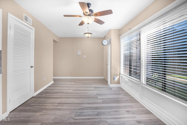 spare room featuring visible vents, baseboards, and wood finished floors