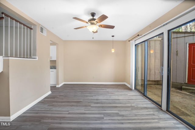 spare room with a ceiling fan, baseboards, visible vents, and wood finished floors