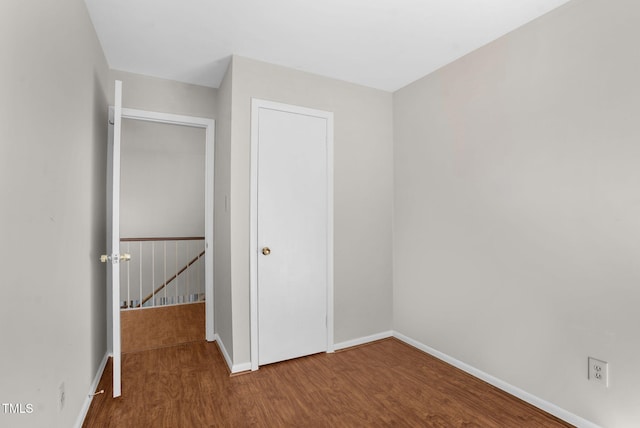 unfurnished bedroom featuring wood finished floors and baseboards