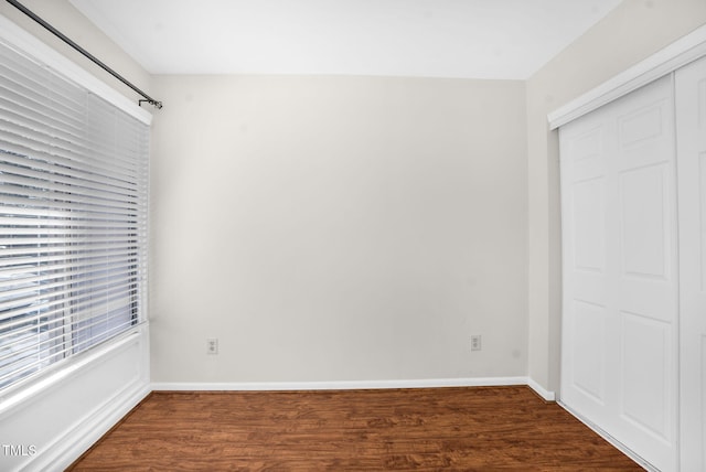 unfurnished bedroom with a closet, baseboards, and wood finished floors