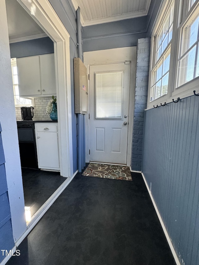 doorway with baseboards and ornamental molding