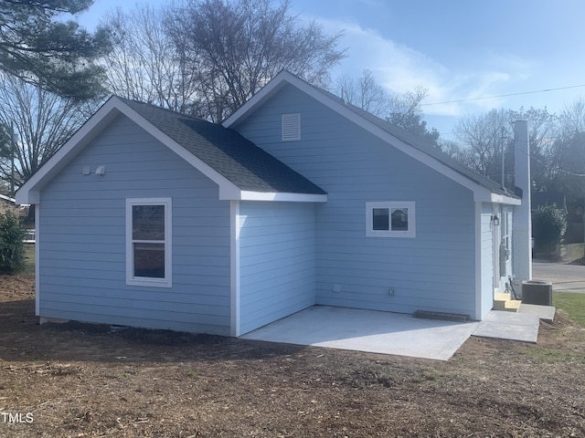 back of house featuring a shingled roof and a patio area