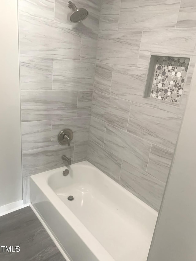 bathroom featuring washtub / shower combination and baseboards