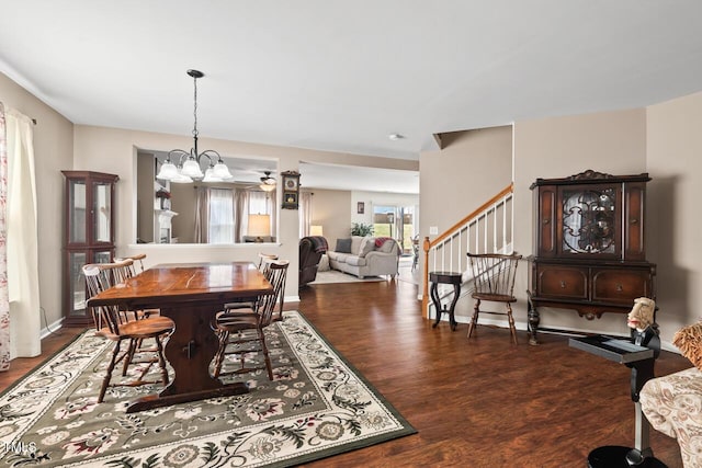 dining space with stairs, a notable chandelier, baseboards, and wood finished floors