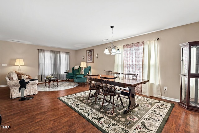 dining area featuring wood finished floors, visible vents, baseboards, and an inviting chandelier