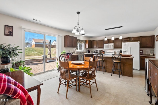 dining area featuring a toaster, visible vents, and a notable chandelier