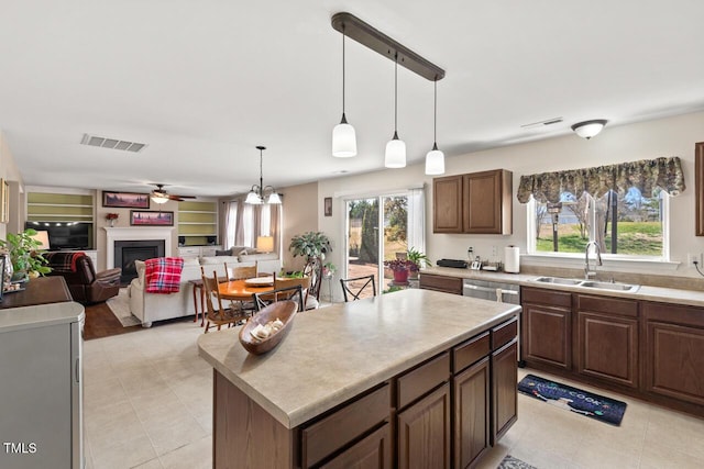 kitchen featuring light countertops, visible vents, a sink, and a fireplace