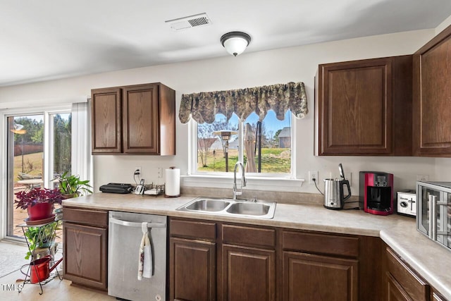 kitchen with a sink, visible vents, light countertops, and stainless steel dishwasher