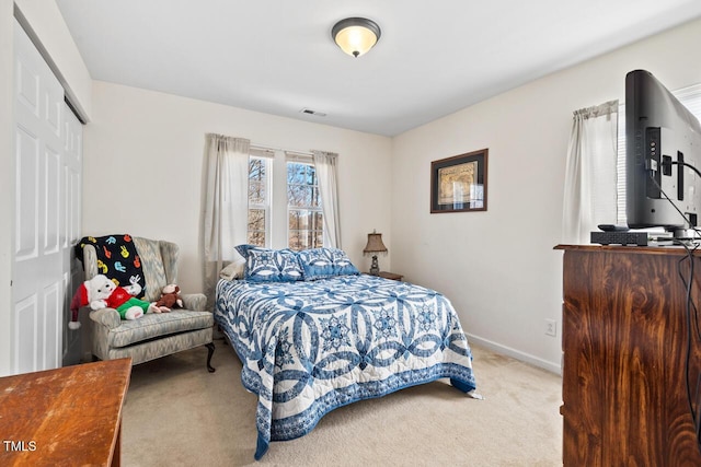 carpeted bedroom with visible vents, baseboards, and a closet