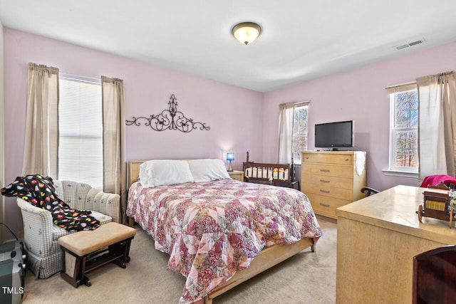 bedroom featuring light carpet, multiple windows, and visible vents