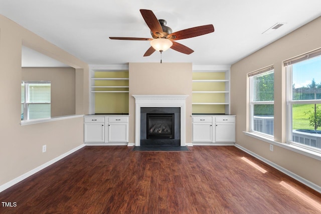 634 Conover Rd, Durham, NC 27703 - unfurnished living room with dark wood-type flooring, built in features, a fireplace with flush hearth, baseboards, and a ceiling fan