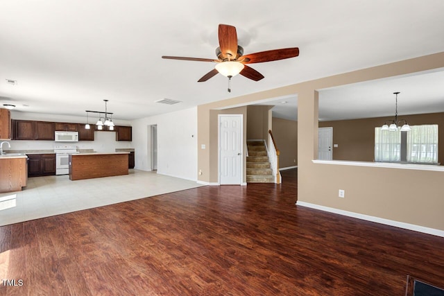634 Conover Rd, Durham, NC 27703 - unfurnished living room with a chandelier, baseboards, ceiling fan, and stairway