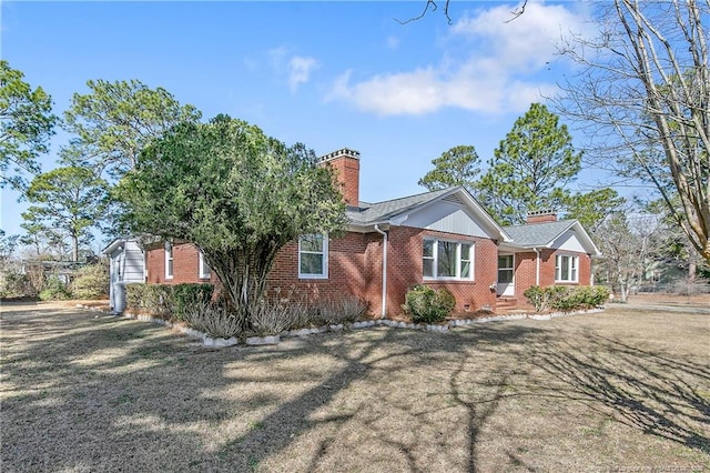 view of front of property with a chimney and brick siding