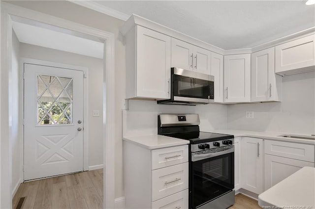 kitchen with white cabinetry, stainless steel appliances, and light countertops