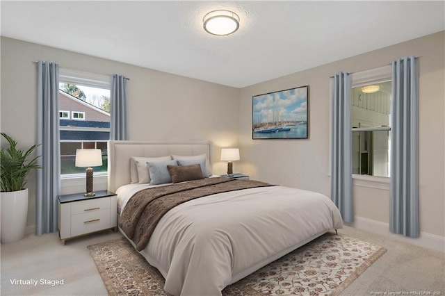 bedroom featuring light carpet and baseboards